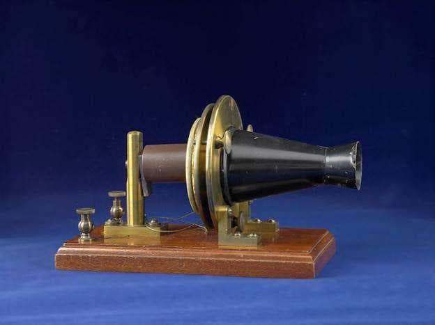 Alexander Graham Bell’s 1876 experimental telephone, a wooden base with a brass electromagnet and a cone-shaped tin mouthpiece.