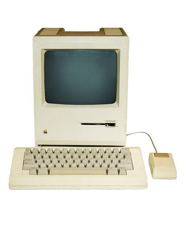 The original beige Apple Macintosh with its keyboard and single-button mouse.