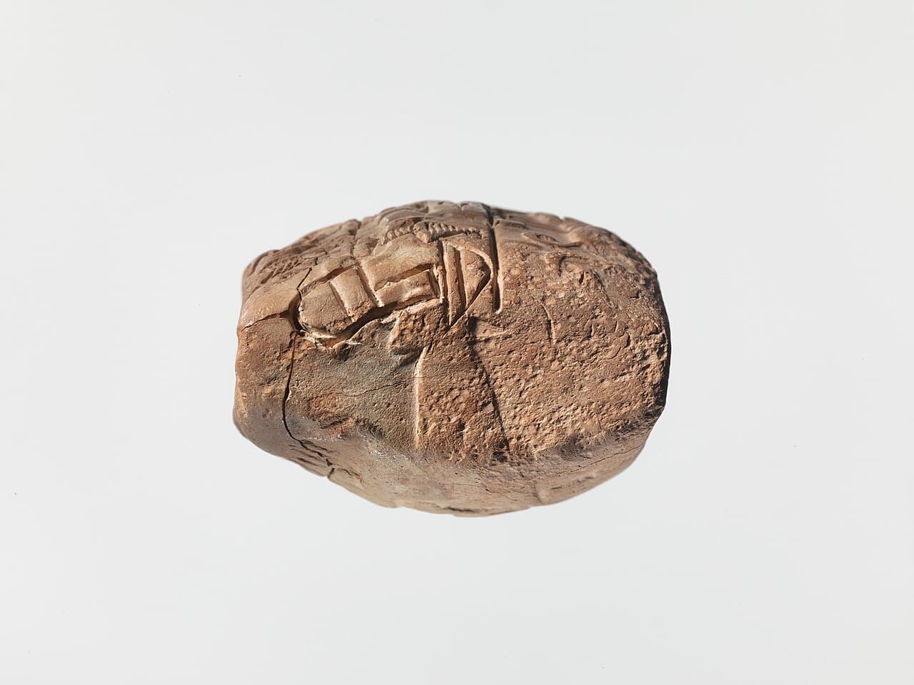 Sumerian clay tablet in proto-cuneiform recording a distribution of barley, with a cylinder seal impression of a figure, dogs, and boars.